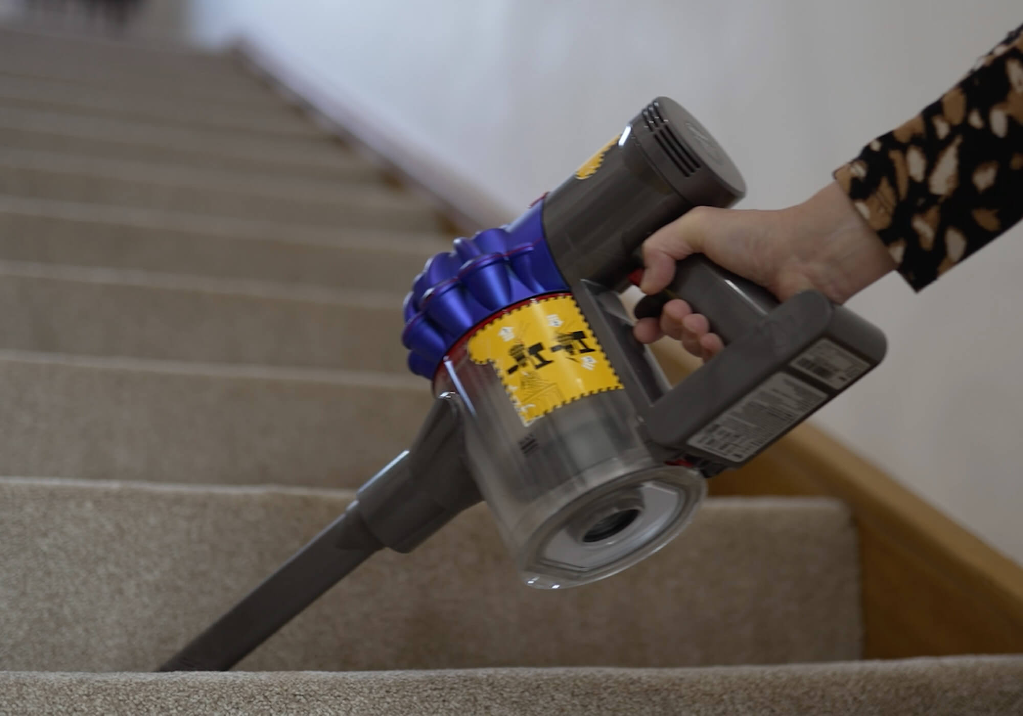 Close up shot of a person vacuuming stairs in their home